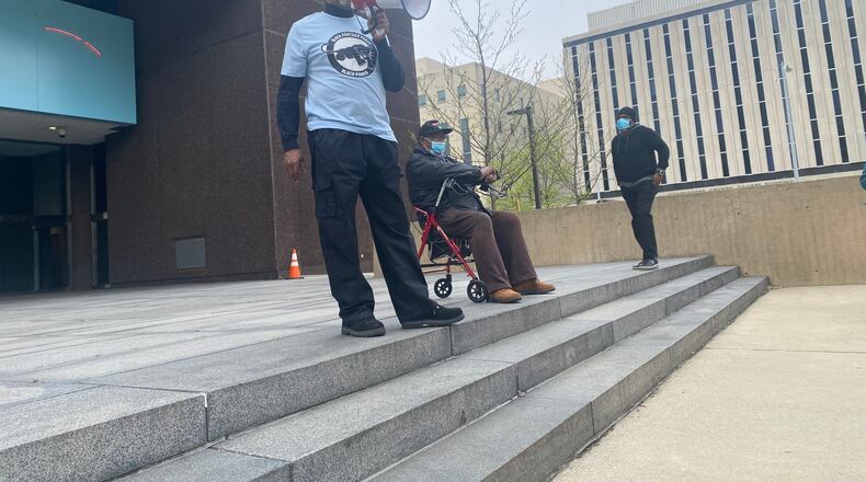 Donald Domineck of the New Black Panther Party speaks at a protest in front of the Dayton Federal Building on West Second Street Saturday morning to protest the recent and ongoing killings of Black men by police. Seated next to him is Bishop Richard Cox of Parenthood Ministries and Chad White Sr. of The Word Church is on the far right. About 25 people attended the protest, which was organized by the Better Dayton Coalition. Eileen McClory / Staff