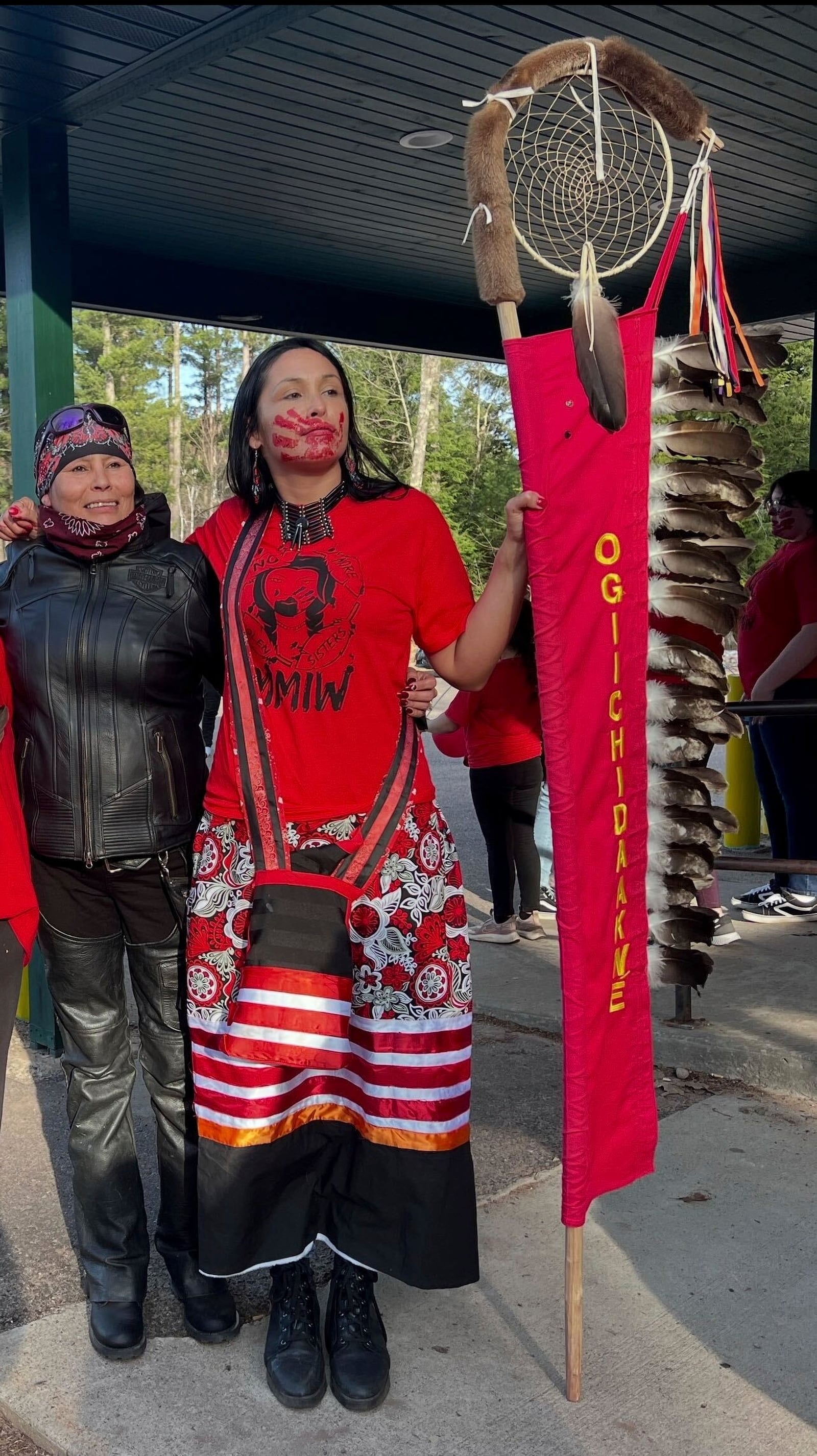 In this photo provided by Shawn Milligan, motorcycle rider Lisa Milligan of the Forest County Potawatomi tribe poses with a young activist at a Missing & Murdered Indigenous Women event at the Lac du Flambeau Band of Lake Superior Chippewa reservation in Wisconsin, May 5, 2022. (Shawn Milligan via AP)