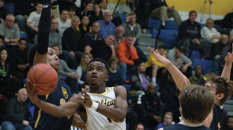 Springfield’s Michael Wallace drives between Moeller defenders during Moeller’s 57-39 victory Saturday night. Wallace led the Wildcats with 11 points. Jeff Gilbert/CONTRIBUTED