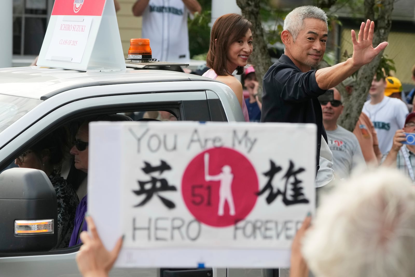 Baseball Hall of Fame inductee Ichiro Suzuki, right, and his wife Yumiko Suzuki smile during the Baseball Hall of Fame Parade of Legends in Cooperstown, N.Y., Saturday, July 26, 2025. (AP Photo/Seth Wenig)