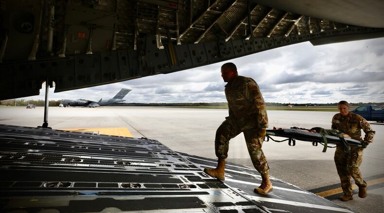 Crewmembers of a C-17 Globemaster III load dummies onto the aircraft during a mock medical evacuation drill at Wright Patterson Air Force Base, Wednesday, October 16, 2024. MARSHALL GORBY \STAFF