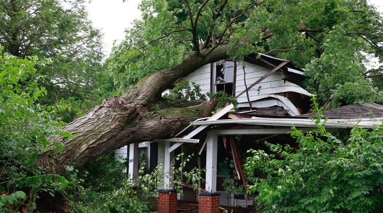 A tree fell on a vacant house on Lincoln Street in Christiansburg in Champaign County on Sunday. Crews were in the village to clean up damage on Monday, June 12, 2023. BILL LACKEY/STAFF