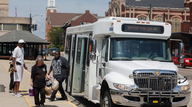 Myers Market employee Amy Riley, center, exits a SCAT bus on West High Street on the afternoon of Friday, June 20, 2025, in Springfield. JOSEPH COOKE/STAFF