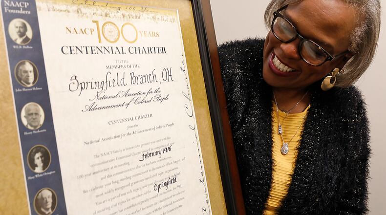 Denise Williams, president of the Springfield NAACP, looks over the centennial certificate recognizing the 100 years of the Springfield Unit’s existence. Bill Lackey/Staff