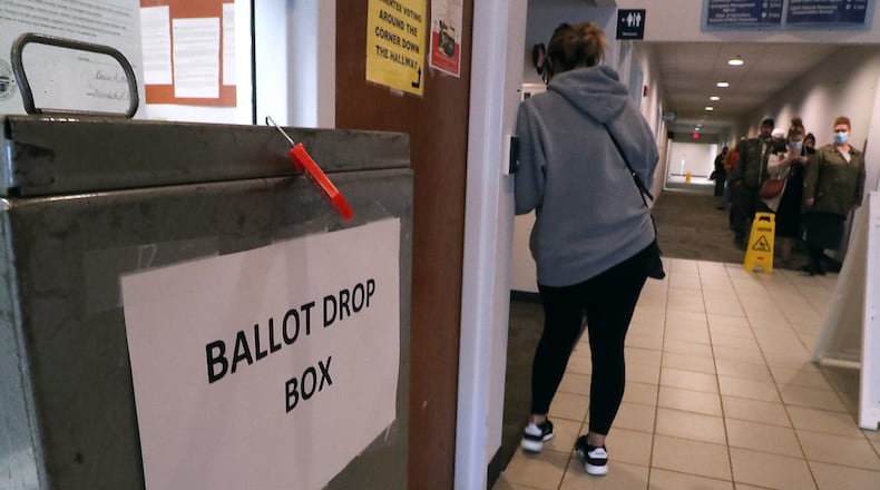 Voters wait in a line stretching down the hall at the Champaign County Board of Elections to vote in 2020. BILL LACKEY/STAFF