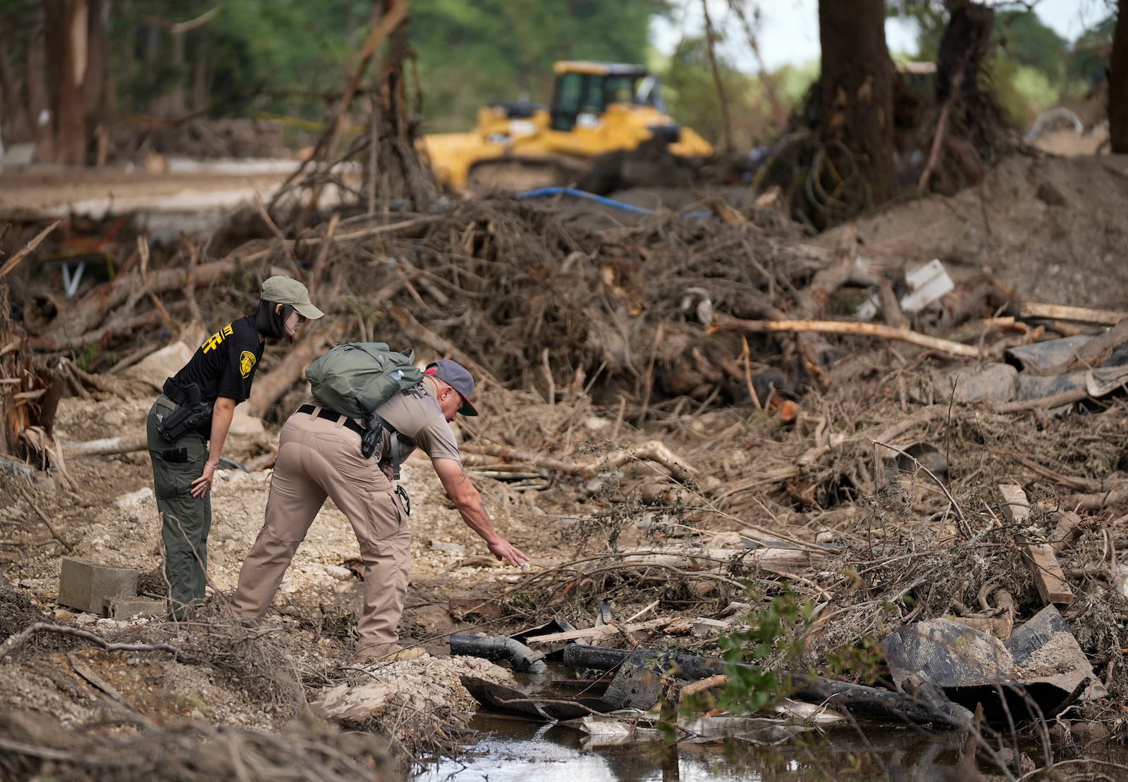 Upton County sheriff deputies do search and recovery work on the banks of the Guadalupe River in Ingram, Texas, Tuesday, July 8, 2025, after the Fourth of July flood. (Jay Janner/Austin American-Statesman via AP)