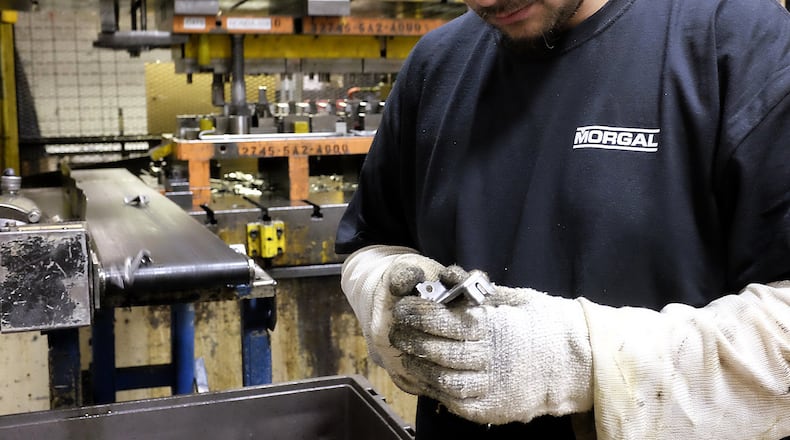 A Morgal employee checks one of the metal parts the company was manufacturing for Honda at the McGregor Metalworking facility on South Yellow Springs Street. Bill Lackey/Staff