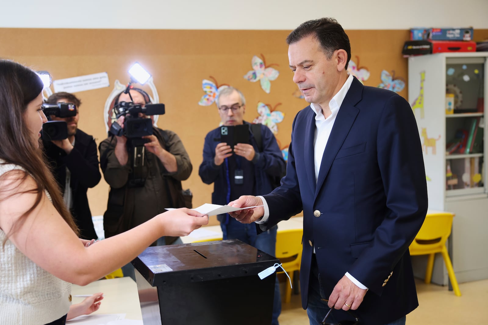 Incumbent Prime Minister and leader of the center-right Social Democratic Party Luis Montenegro picks up his ballot to vote in Portugal's general election at polling station in Espinho, Portugal, Sunday, May 18, 2025. (AP Photo/Luis Vieira)