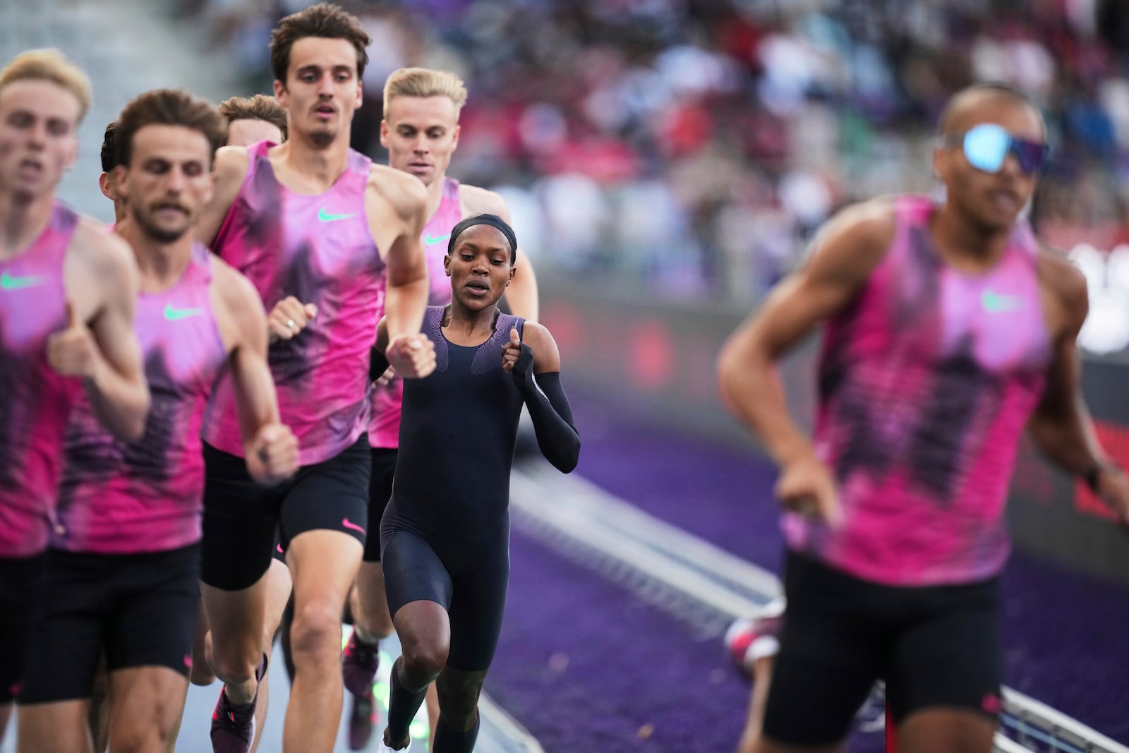 Faith Kipyegon, from Kenya, runs surrounded by her pacers in an attempt to become the first woman to run a mile in under four minutes, at Stade Charlety in Paris, Thursday, June 26, 2025. (AP Photo/Christophe Ena)