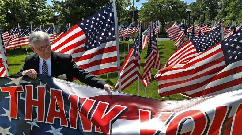 Ron Staffan, an employee of Jackson Lytle & Lewis Life Celebration Center, straightens the sign in front of the Field Of Honor on the Center’s front lawn along North Limestone Street. The Field of Honor, made up of hundreds of American flags, was on display from June 6-14. The purpose of the Field Of Honor is to show appreciation for active members of the military as well as our veterans. This was the 11th Honor Field that Jackson, Lytle & Lewis has hosted. BILL LACKEY/STAFF