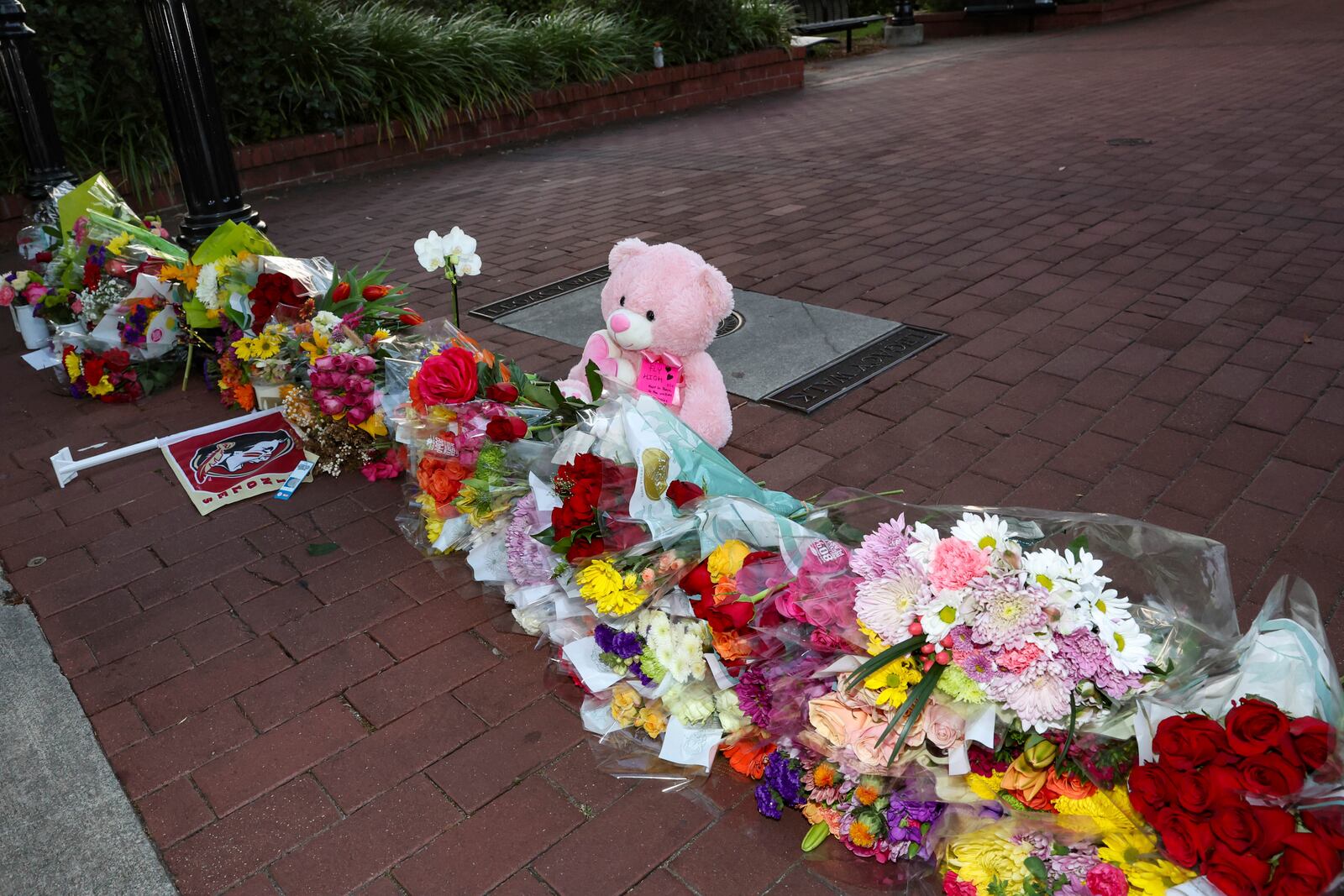 An impromptu memorial of flowers and other items laid near the center of the Florida State campus in sight of the Student Union building, Tallahassee, Fla., Thursday, April 17, 2025. (AP Photo/Gary McCullough)