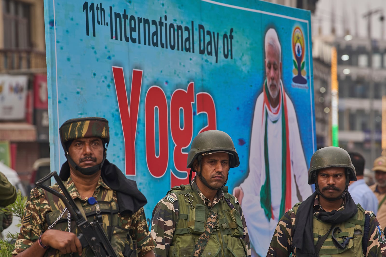Indian paramilitary soldiers stand guard as people perform yoga on International Day of Yoga at the city centre in Srinagar, Indian controlled Kashmir, Saturday, June 21, 2025. (AP Photo/Dar Yasin)
