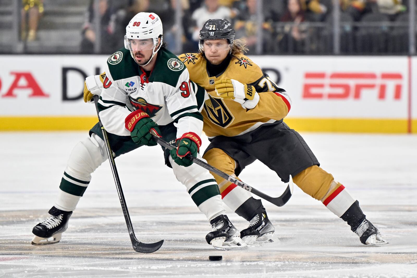 Minnesota Wild left wing Marcus Johansson (90) and Vegas Golden Knights center William Karlsson (71) vie for the puck during the second period of Game 5 of a first-round NHL hockey playoff series Tuesday, April 29, 2025, in Las Vegas. (AP Photo/David Becker)