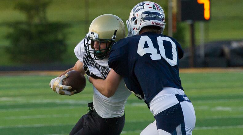 Catholic Central’s Thomas Kavanagh (right) tries to avoid a tackle by Mason’s Jake Grapinski uring the Miami Valley Football Coaches Association’s all-star game on Friday night at Centerville Stadium. Contriubted Photo by Bryant Billing