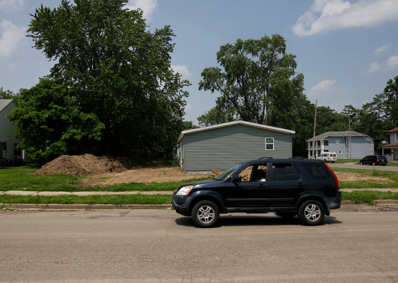 A vehicle drives on East Liberty Street on Wednesday, June 4, 2025, in Springfield. Four new homes are being built here by Clark County Land Bank. JOSEPH COOKE/STAFF