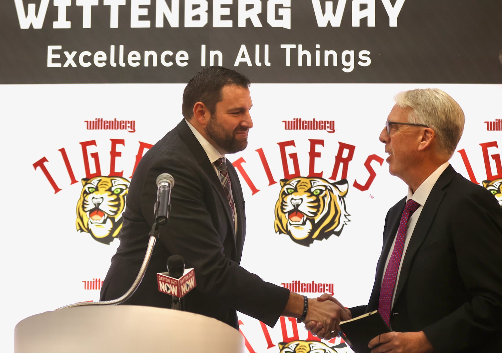 BJ Coad, left, shakes hands with Wittenberg athletic director Brian Agler after being introduced as the new head football coach on Monday, Dec. 1, 2025, at the The Health, Wellness & Athletics Complex in Springfield. David Jablonski/Staff