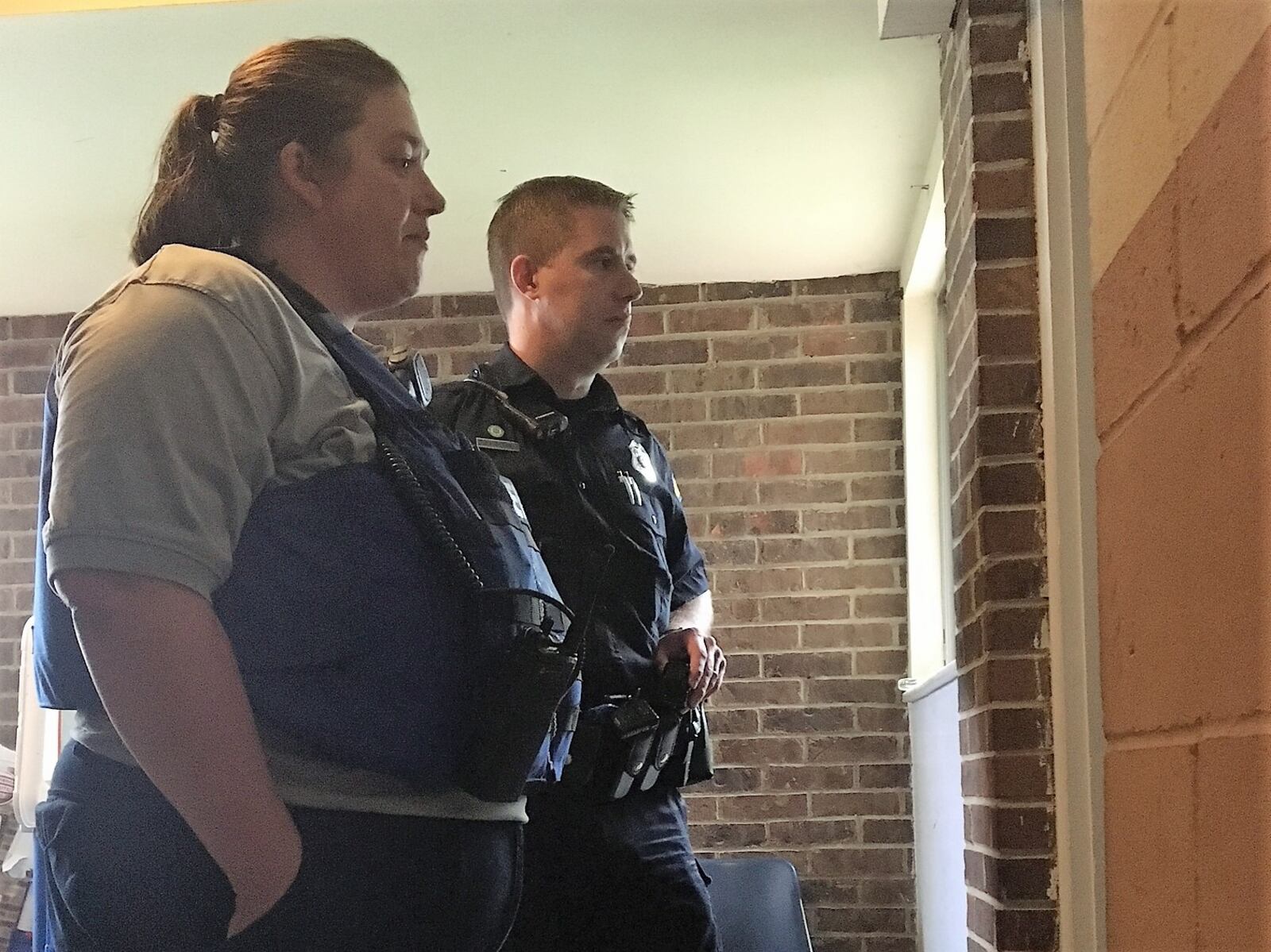 Dayton EMT Amy  Dunkin and Police Officer Jason Olson talk to a recent overdose survivor in  the doorway to his apartment on Beckman Street, June 12, 2018. KATIE WEDELL/STAFF