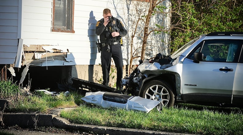 A member of the Springfield Police Division take photos of a Jeep that struck a house on West Pleasant Street early Wednesday morning, April 3, 2024. Driver of the vehicle transported by squad to local hospital. The accident remains under investigation. MARSHALL GORBY \STAFF