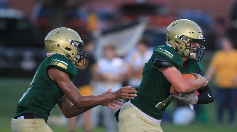 Catholic Central's Ty Myers Jr. hands the ball to Tyler Young during a game against West Jefferson at Hallinean Field on Friday, Sept. 17, 2021, in Springfield. David Jablonsk/Staff