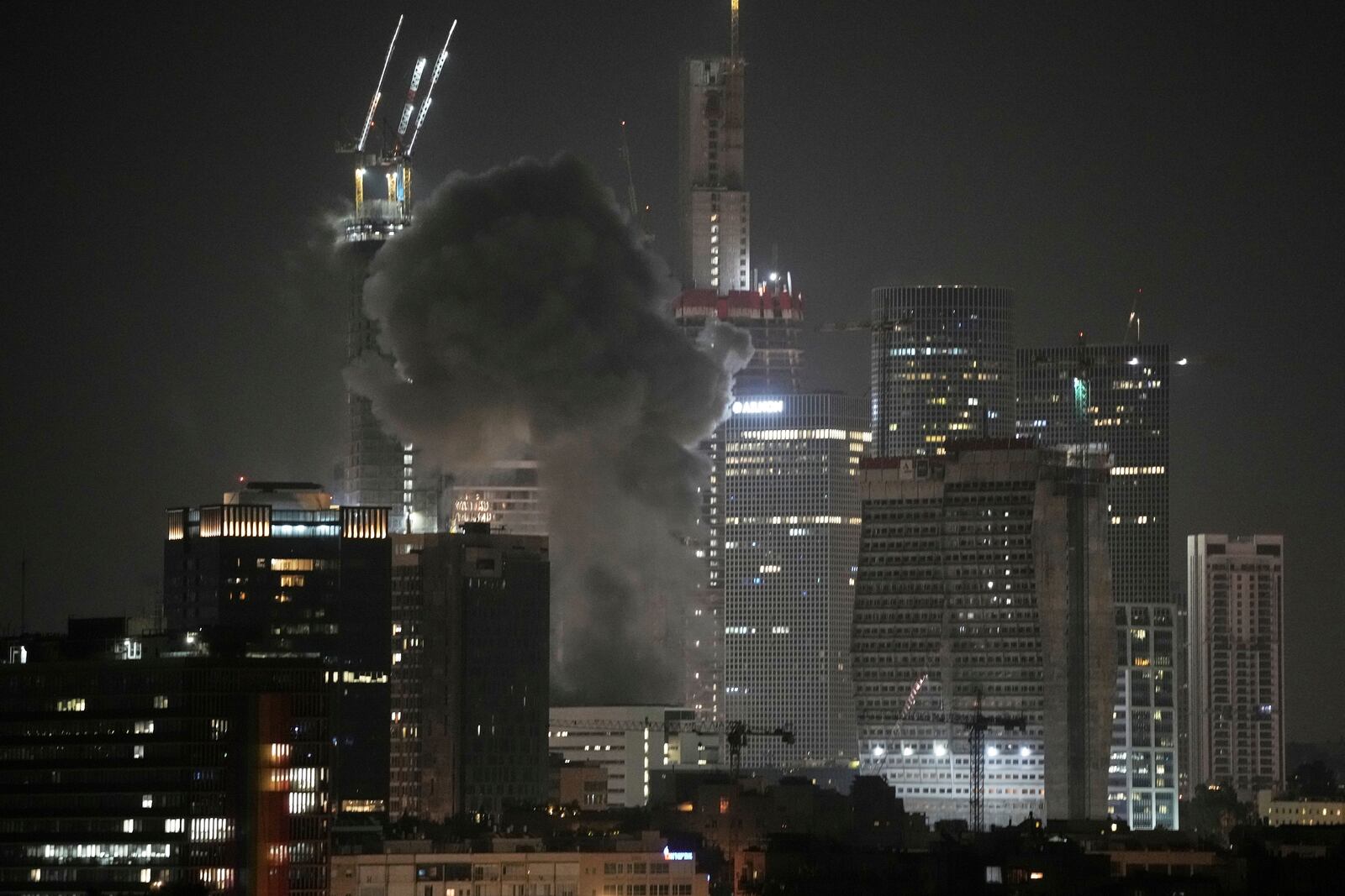 Smoke billows after a projectile hit a building in Tel Aviv, Israel, early Saturday, June 14, 2025. (AP Photo/Leo Correa)