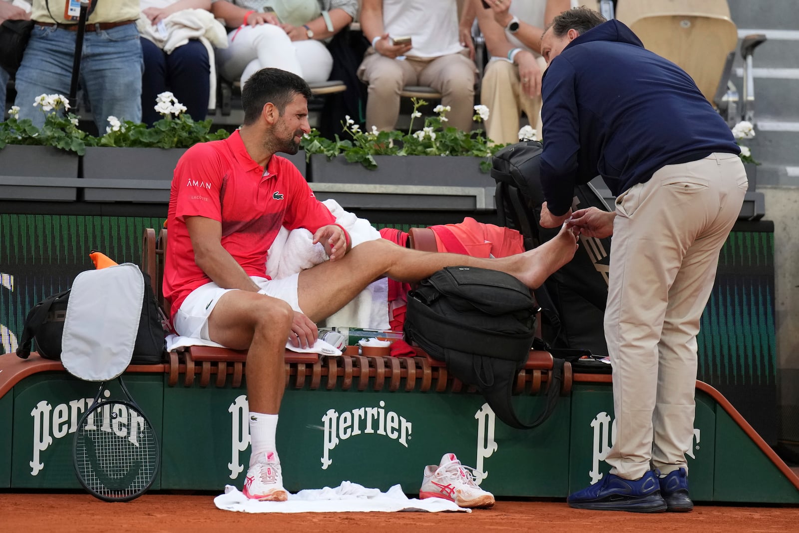 Serbia's Novak Djokovic receives medical assistance during his second round match of the French Tennis Open against France's Corentin Moutet, at the Roland-Garros stadium, in Paris, Thursday, May 29, 2025. (AP Photo/Christophe Ena)