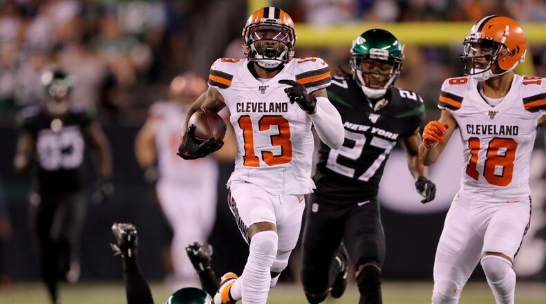 EAST RUTHERFORD, NEW JERSEY - SEPTEMBER 16: Odell Beckham Jr. #13 of the Cleveland Browns breaks free from Brian Poole #34 and Darryl Roberts #27 of the New York Jets to run the ball 89 yards in for the touchdown in the third quarter at MetLife Stadium on September 16, 2019 in East Rutherford, New Jersey. (Photo by Elsa/Getty Images)