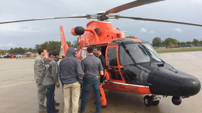A student capstone team from Michigan Technological University gets a close look at a maritime rescue helicopter during an Oct. 19, 2018, team gathering. The group is collaborating with the Air Force Research Laboratory and the U.S. Coast Guard to design a compact, high-capacity maritime rescue device. (Photo courtesy of Mark Bobal, U.S. Coast Guard)