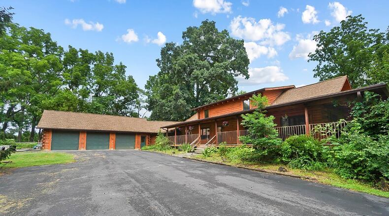 This custom log home sits on 3.59 wooded acres well back from the road. It features a first floor primary suite and vaulted beamed ceilings.