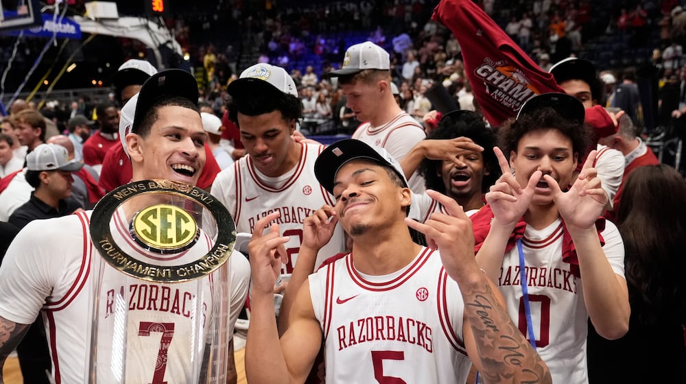 Arkansas' Trevon Brazile (7), Darius Acuff Jr. (5) and Jaden Karuletwa (0) celebrate after beating Vanderbilt in an NCAA college basketball game in the final of the Southeastern Conference tournament Sunday, March 15, 2026, in Nashville, Tenn. (AP Photo/George Walker IV)