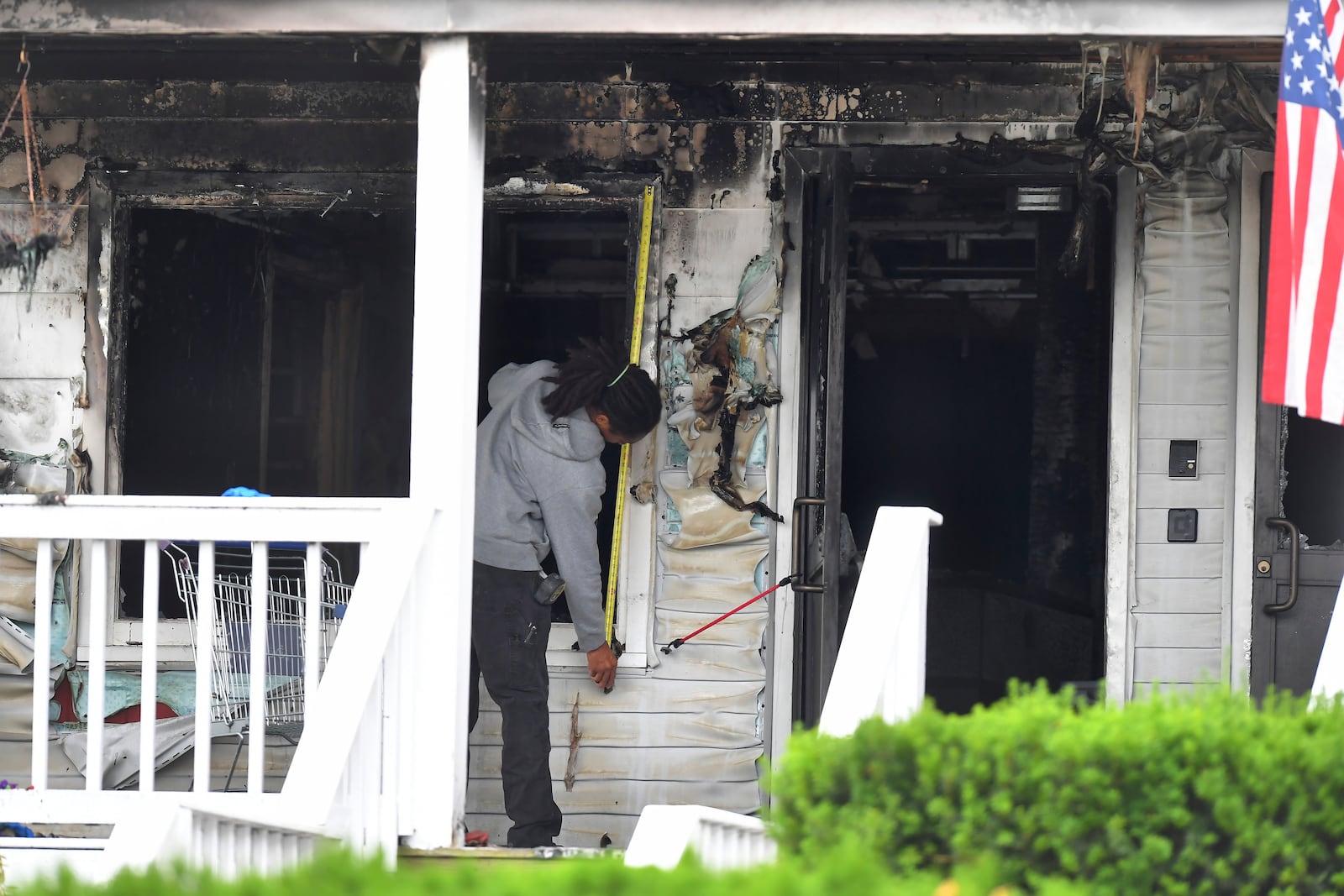 An investigator takes measurements Monday, July 14, 2025, near an entrance to the Gabriel House assisted living facility following a fire that started late Sunday in Fall River, Mass. (AP Photo/Steven Senne)