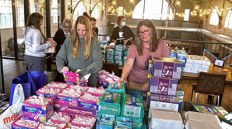 Volunteers prepare materials to be used to create Period Kits at an event at COhatch The Marketplace in downtown Springfield on Tuesday, May 2, 2023. The feminine hygiene products that will be donated to Clark County organizations. BEN McLAUGHLIN/STAFF