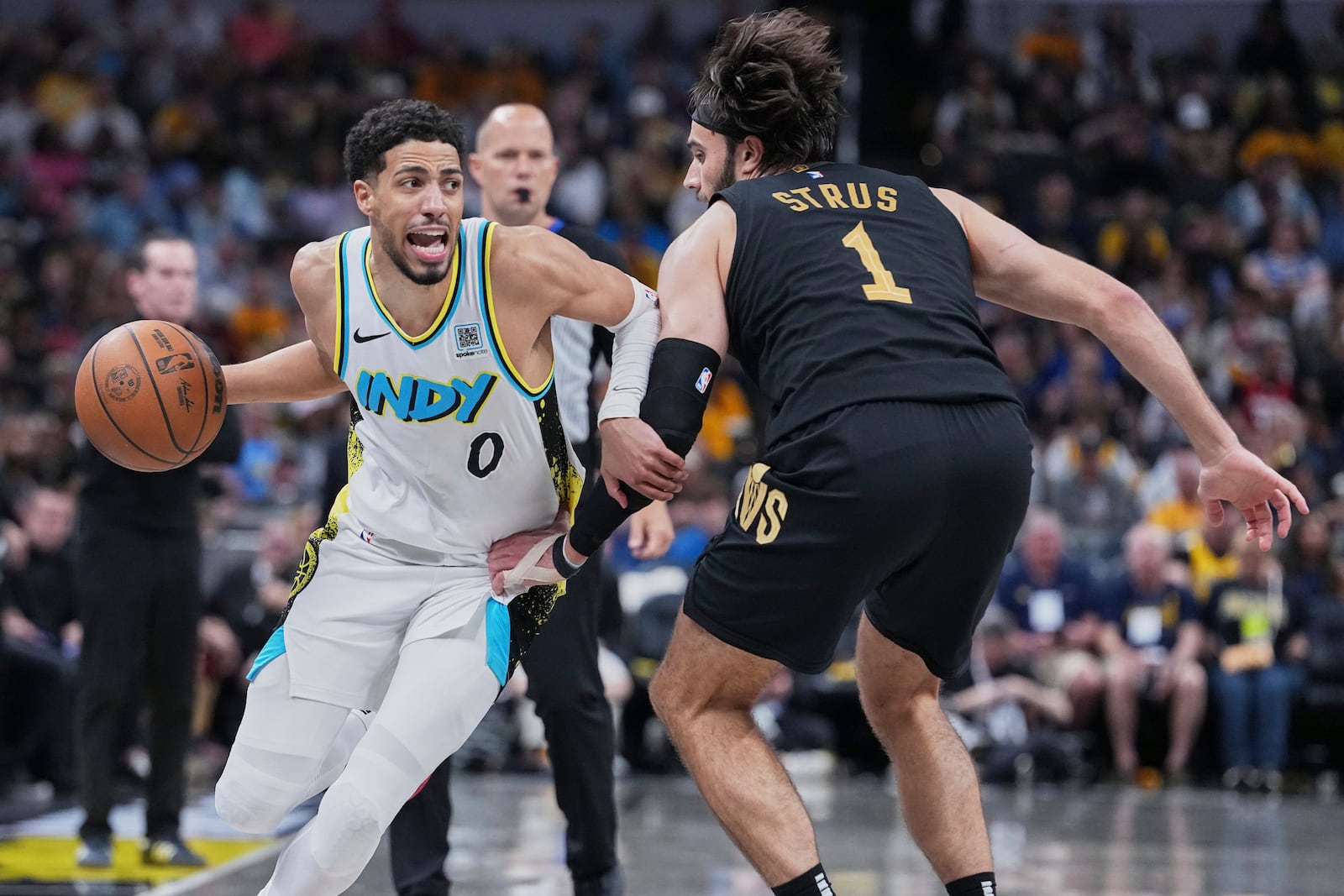Indiana Pacers guard Tyrese Haliburton (0) drives to the basket against Cleveland Cavaliers guard Max Strus (1) in the second half of Game 4 in the Eastern Conference semifinals of the NBA basketball playoffs in Indianapolis, Sunday, May 11, 2025. (AP Photo/Michael Conroy)