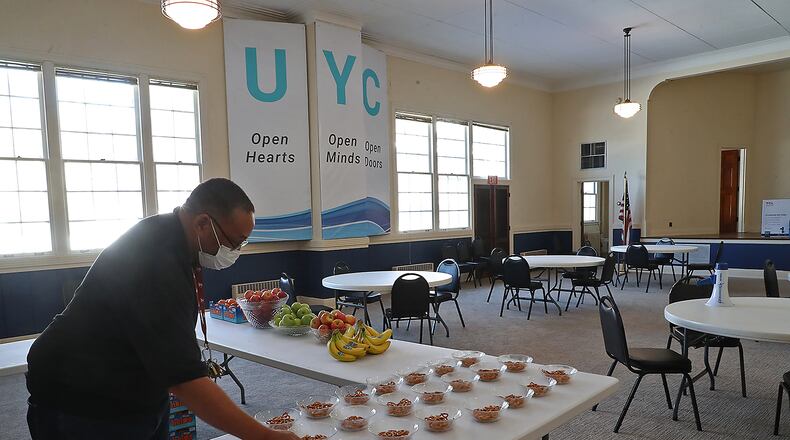 Charles Williams, a voluteer at the Urbana Youth Center, puts snacks out for the young people Tuesday before they arrive after school. BILL LACKEY/STAFF