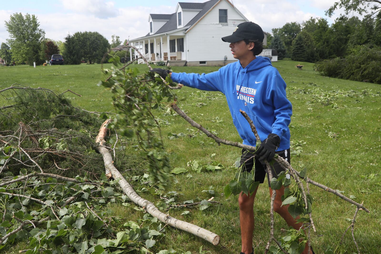 Noah Jordan helps clean up his family’s German Twp. yard Thursday, June 9, 2022, after Wednesday’s storm toppled several trees. An EF1 tornado touched down north of Springfield. BILL LACKEY/STAFF