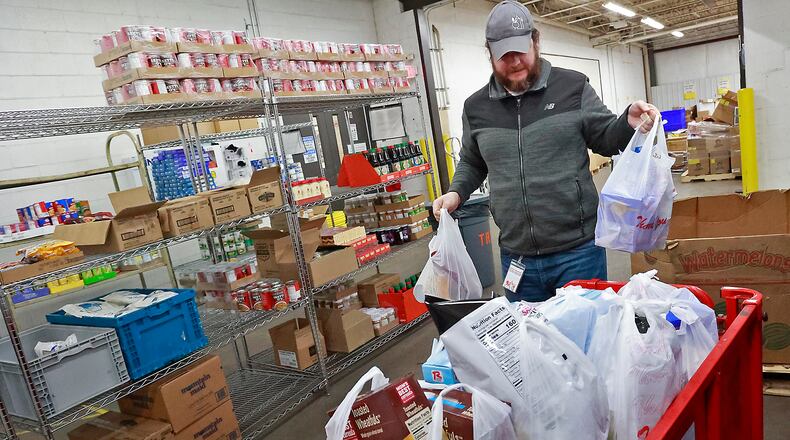 Elliott Martin stocks the food pantry at the Second Harvest Food Bank in this Dec. 5, 2022, file photo. BILL LACKEY/STAFF