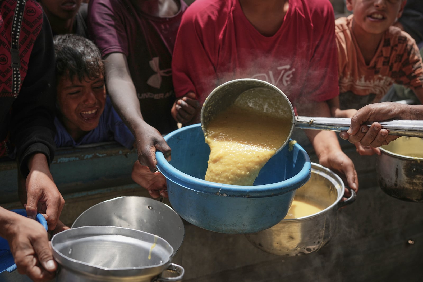 Palestinian children struggle to get donated food at a community kitchen in Khan Younis, southern Gaza Strip, Thursday April 24, 2025.(AP Photo/Abdel Kareem Hana)