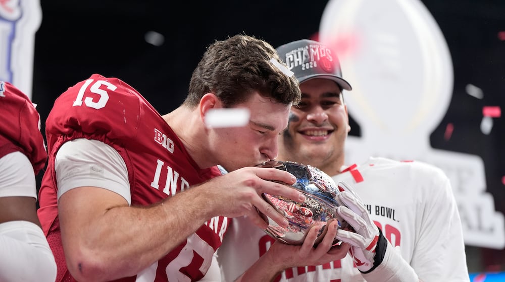 Indiana quarterback Fernando Mendoza (15) kisses the trophy after the Peach Bowl NCAA college football playoff semifinal against Oregon, Friday, Jan. 9, 2026, in Atlanta. (AP Photo/Brynn Anderson)
