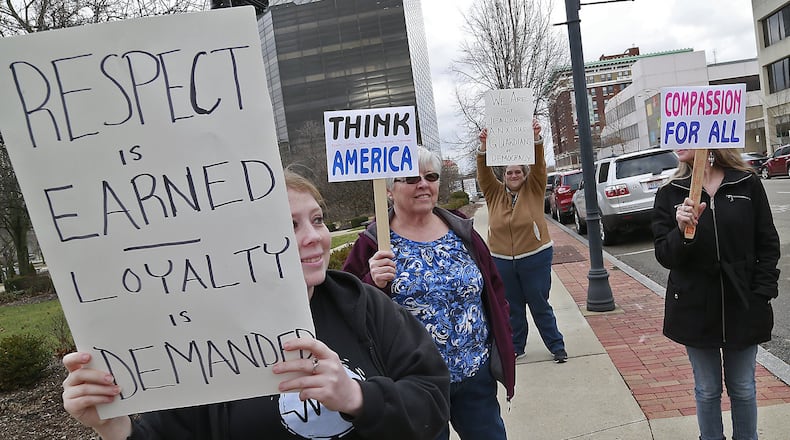 A small group of Donald Trump protestors, including Chelsea LeMaster, left, stand on the corner of Limestone and High Streets with protest signs Friday. Bill Lackey/Staff