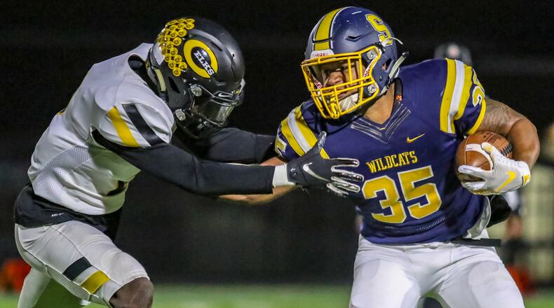 Springfield High School running back Jeff Tolliver stiff arms Centerville’s Maurice Lawrence during their game on Thursday night in Springfield. The Wildcats won 41-28. CONTRIBUTED PHOTO BY MICHAEL COOPER