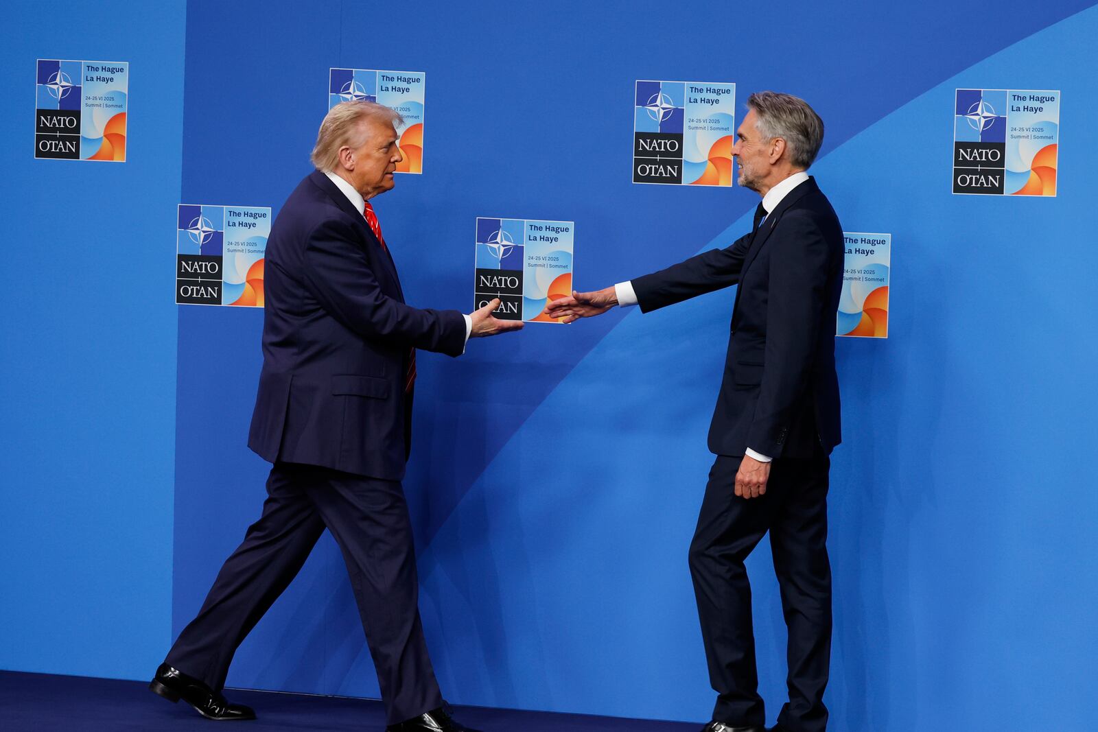 President Donald Trump is greeted by Netherland's Prime Minister Dick Schoof, right, during an official welcome at the NATO summit in The Hague, Netherlands, Wednesday, June 25, 2025. (AP Photo/Geert Vanden Wijngaert)