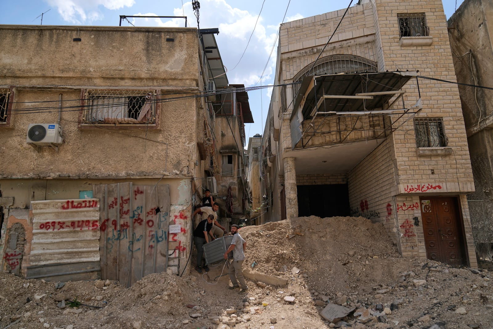 Residents of the now evacuated refugee camp of Tulkarem return to collect belongings before the destruction of their homes as Israeli forces prepare to carry out the demolition of 116 homes across the two refugee camps of the Israeli occupied West Bank city of Tulkarem, Friday, May 2, 2025. (AP Photo/Nasser Nasser)
