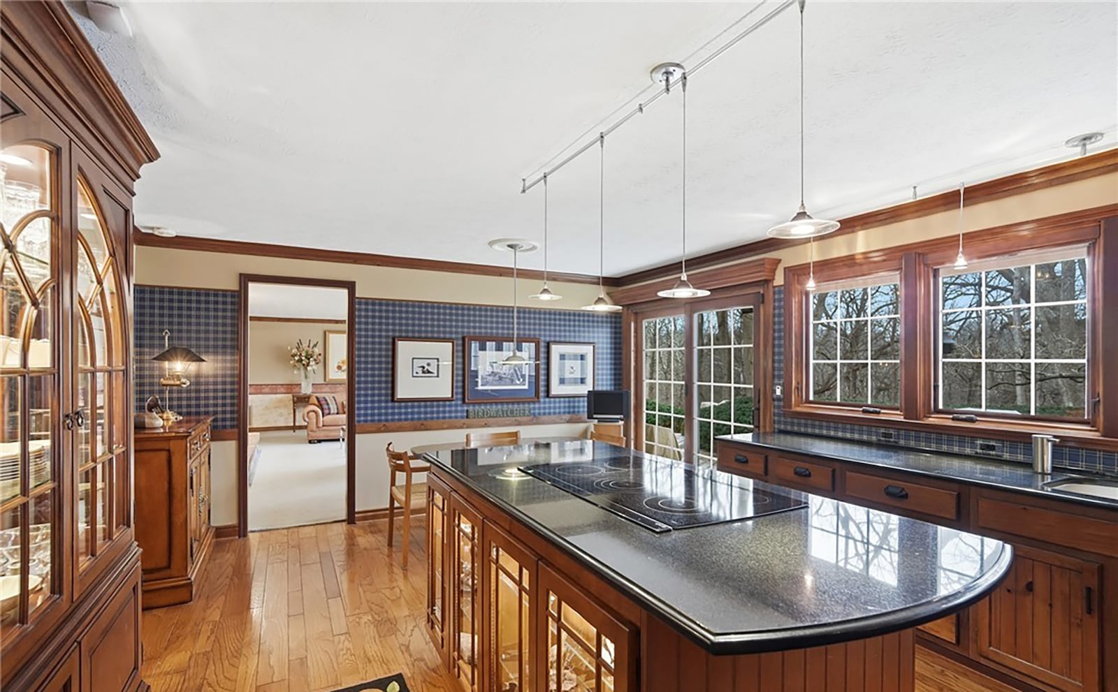 The kitchen has hardwood floors, custom cabinets, solid surface countertops and a breakfast area. Doors open to the back patio. CONTRIBUTED