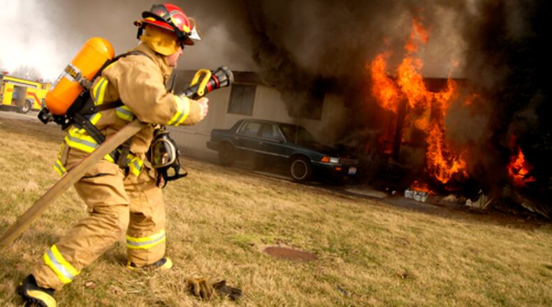A member of the German Twp. fire department rushes into position to attack the flames consuming a mobile home. German Twp.'s fire department services half of Mad River Twp. in Champaign County.