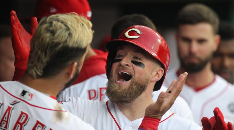 The Reds’ Tucker Barnhart celebrates with Eugenio Suarez after hitting a home run in the fourth inning against the Braves on Tuesday, April 23, 2019, at Great American Ball Park in Cincinnati. David Jablonski/Staff