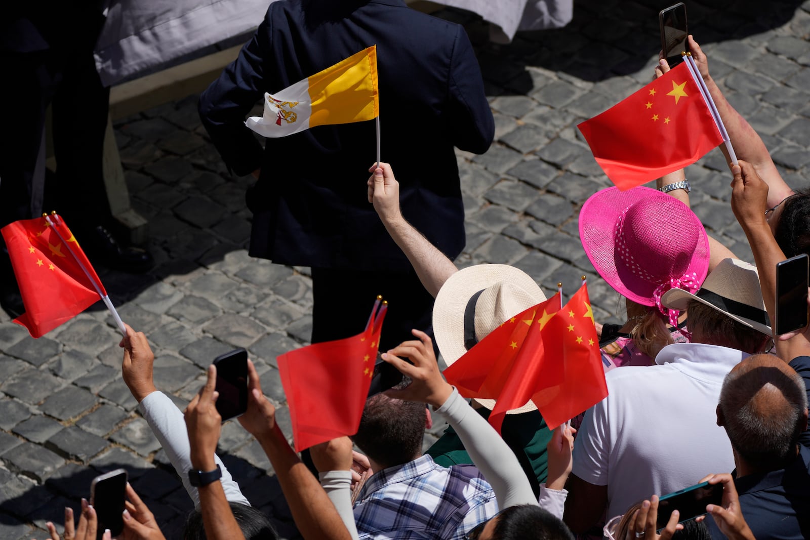 Faithful cheer as they hold China and Vatican flags during the noon Angelus prayer with Pope Leon XIV, in the square in front of the Apostolic Palace for in Castel Gandolfo, Italy, Sunday, July 20, 2025. (AP Photo/Gregorio Borgia)