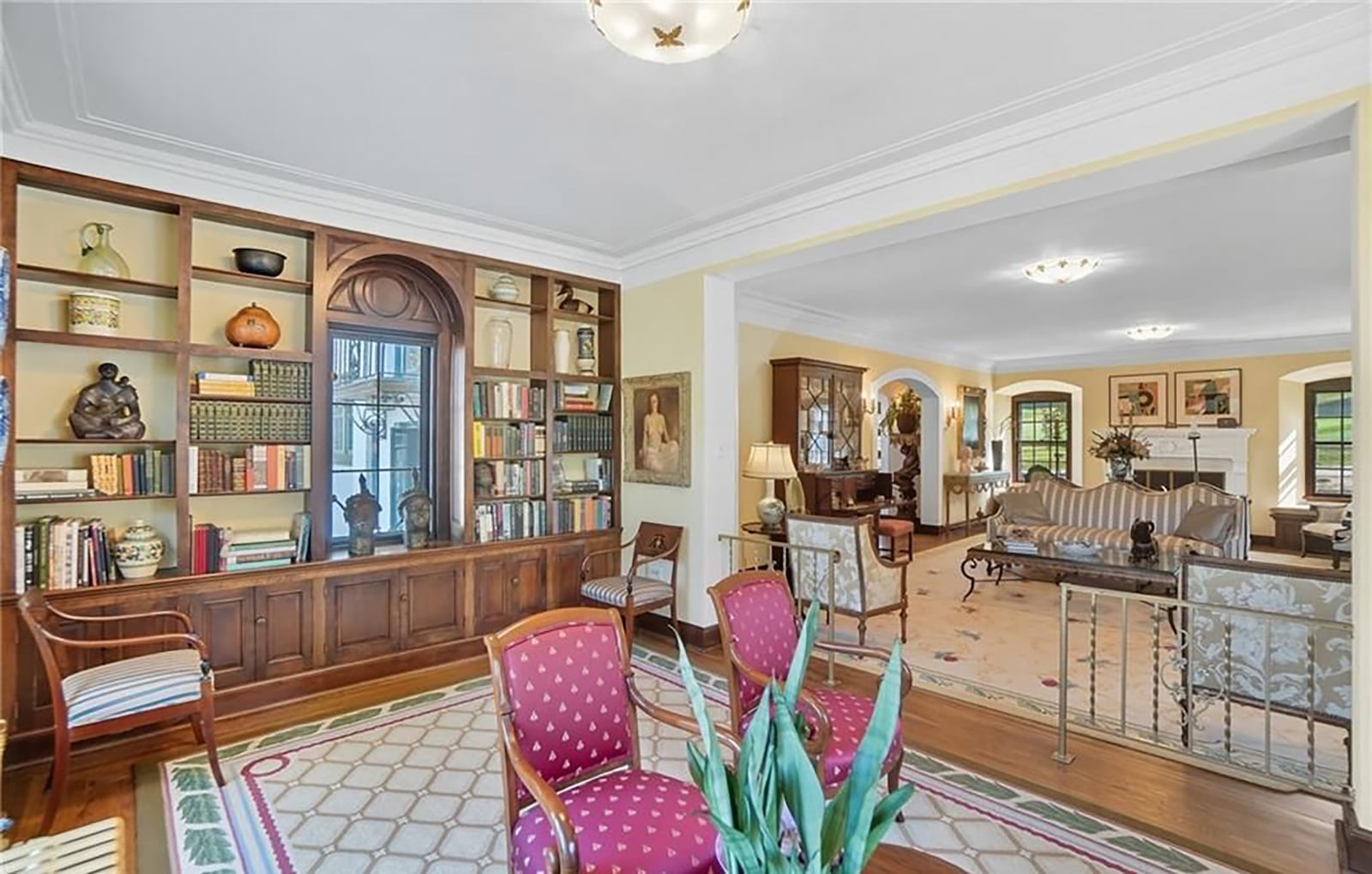 The library sitting room on the main floor is off the living room and has hardwood floors, a wall of built in bookcases and crown molding. CONTRIBUTED