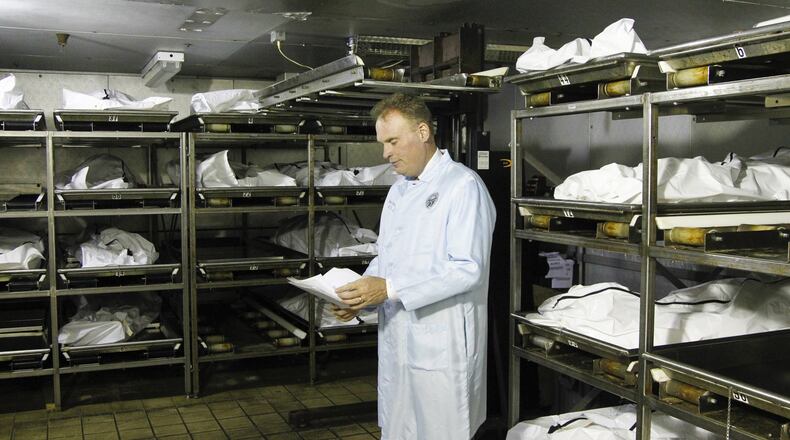 Montgomery County Coroner Dr. Kent Harshbarger is seen in the cooler at the morgue where up to 60 percent of the bodies are those who died of drug overdoses. CHRIS STEWART / STAFF