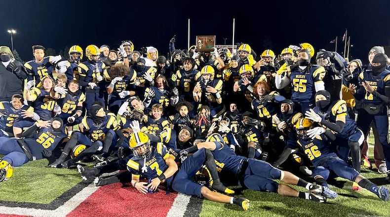 The Springfield High School football team poses for a photo with the Division I, Region 2 championship trophy after defeating Olentangy Liberty 35-7 on Friday night at London's Bowlus Field. CONTRIBUTED PHOTO BY MICHAEL COOPER
