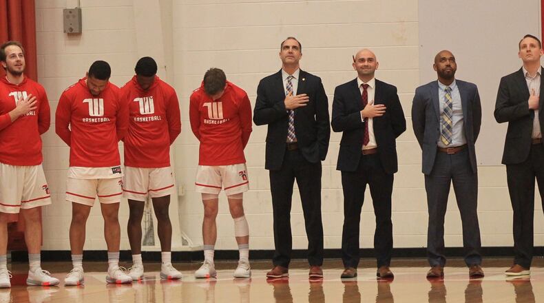 Wittenberg players and coaches, including head coach Matt Croci, center, stand for the national anthem before a game against Denison on Wednesday, Feb. 5, 2020, at Pam Evans Smith Arena in Springfield. David Jablonski/Staff