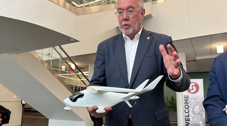 Sinclair Community College President Steven Johnson holding a model of the BETA Technologies’ electric aircraft, the ALIA CTOL (Conventional Takeoff and Landing Aircraft) that the college hopes to have in the first quarter of 2026. THOMAS GNAU/STAFF
